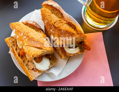 Traditionelle französische Pan bagnat - lecker Sandwich mit Thunfisch, hart gekochte Eier, Sardellen und geschmorte Paprika Stockfoto