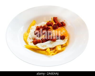 Leckere Spiegeleier mit beliebten spanischen Chistorra wurst und Pommes frites serviert. Auf weissem Hintergrund Stockfoto