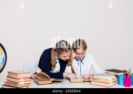 Zwei schulmädchen Mädchen mit Büchern in der Schule Schreibtisch Stockfoto