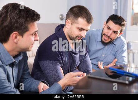 Zwei gestörte Männer, ernstes Gespräch mit ihrem Freund zu Hause Stockfoto