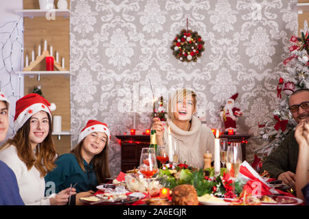 Das zusammengesetzte Bild im großen Familie mit Blick auf die Kamera und das Spielen mit hand Feuerwerk an Weihnachten feiern. Stockfoto