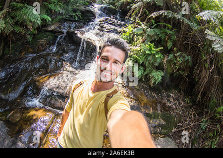 Gutaussehender Reisender, der ein Selfie während einer Exkursion in einen Wald nimmt Stockfoto