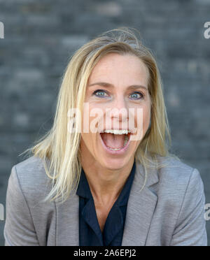 Portrait eines glücklichen vivacious attraktive blauäugige Frau Jubel wie sie lacht in die Kamera im Freien Stockfoto