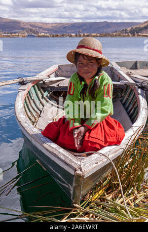 Ein Porträt eines jungen Mädchens in einem Boot sitzen auf einem schwimmenden Uro Insel im Titicacasee, Puno, Peru. Stockfoto