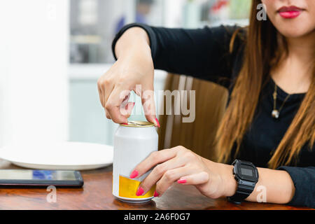 Woman's Hand Öffnung kann der Drink in blur Hintergrund Stockfoto