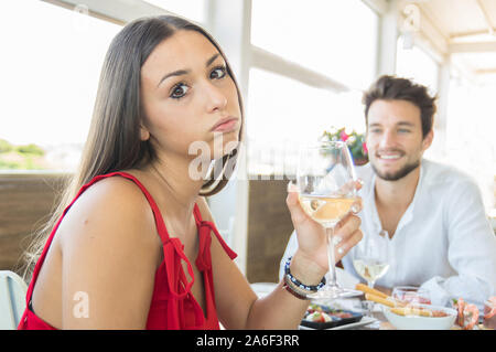 Junge Frau, die verzweifelt Ausdruck Geste auf ein schlechtes Datum im Restaurant Stockfoto