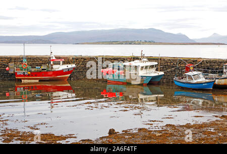 Ein Blick auf die Fischerboote gebunden - von der Pier mit Reflexionen und Broadford Bucht mit Pabay im Hintergrund bei Broadford, Isle of Skye, Großbritannien, Schottland. Stockfoto