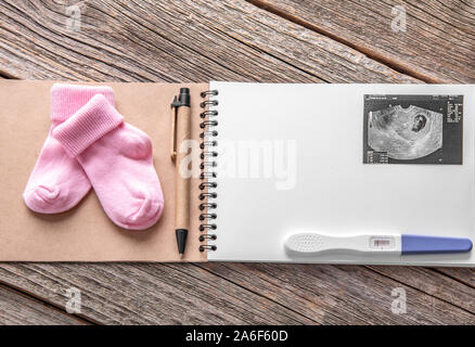 Schwangerschaft Test als noch Leben auf einer hölzernen Hintergrund. Stockfoto