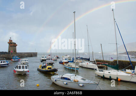 Regenbogen über dem Meer, Boote, Hafen und Strand in Lynmouth bei stürmischem Wetter, Devon, UK, September. Höhe Tide, Stockfoto