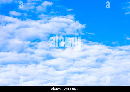 Abnehmende Mond im blauen Himmel, Tageslicht, Tagfahrlicht, weiße Wolken Stockfoto