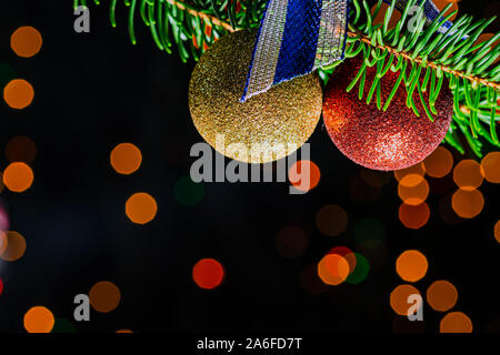 Weihnachtskarte mit roter Kugel und Tanne, dunkle bokeh Hintergrund und Reflexion, festliche Bild mit Kopie Raum Stockfoto
