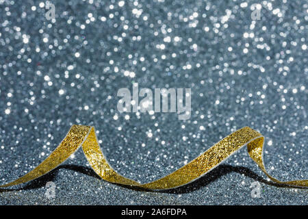 Golden christmas Ribbon auf silbernem Hintergrund, kopieren Raum Bild, Weihnachtskarte mit Defokussierten Glitzereffekt Stockfoto