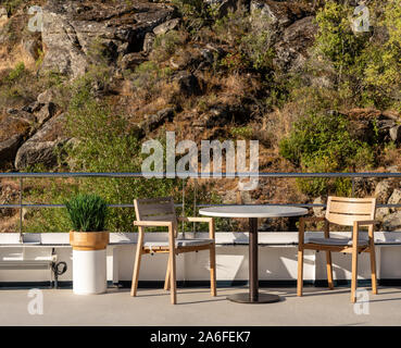 Bar Tisch und zwei Stühle auf dem Deck des kleinen Fluss Kreuzfahrt Yacht segeln durch die schmalen felsigen Schlucht Stockfoto