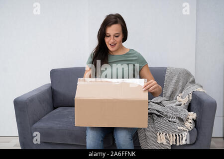 Woman's Hand Öffnen gelieferte Paket zu Hause Stockfoto