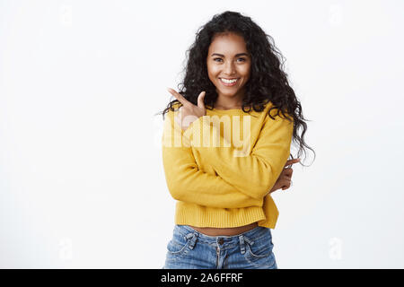 Zuversichtlich verführerische Junge erfolgreiche Frauen african-american mit lockigem Haar, der oberen linken Ecke, zufriedene selbstbewussten Ausdruck, kreuzen Stockfoto