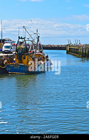 Fischerboote in verschiedenen Größen günstig gegen den Kai mit West Bay Harbor Eingang hinter. Besucher, die an einem sonnigen Tag im Sommer. Stockfoto