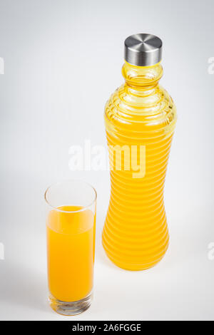 Orangensaft in Glas und Flasche über weißem Hintergrund Stockfoto