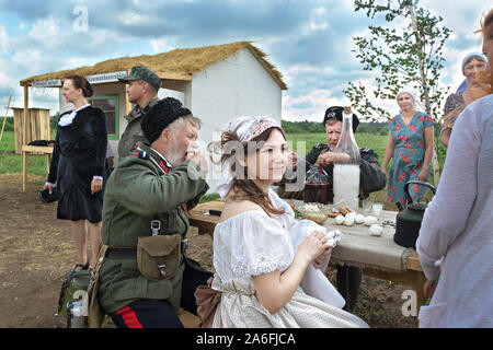 Rekonstruktion der Ereignisse des Zweiten Weltkriegs, Teilnehmer in Form von ROA sitzen am Tisch mit einer Bauernfrau. Russland, Kirov Region 23 Juni Stockfoto