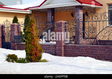 Viel Schnee liegt auf einem Wohngebäude und große Schneeverwehungen um. Jahreszeiten. Stockfoto