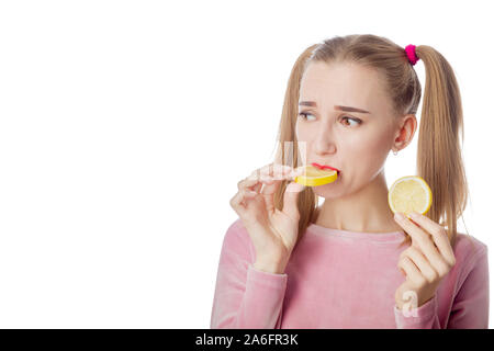 Serious Fun Mädchen isst Zitrone auf weißem Hintergrund mit Kopie Raum Stockfoto