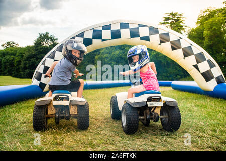 Einen kleinen Jungen mit ADHS, Autismus, Asperger-syndrom reitet ein Quad mit seiner Schwester auf ein Abenteuer Sport Tag für Kinder Stockfoto