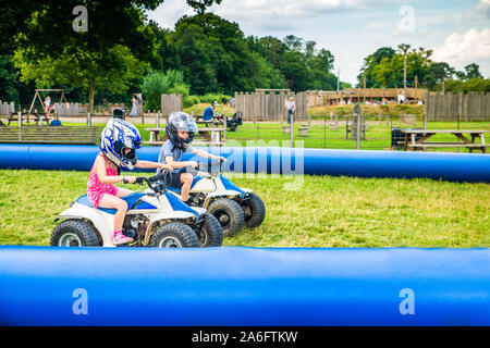 Einen kleinen Jungen mit ADHS, Autismus, Asperger-syndrom reitet ein Quad mit seiner Schwester auf ein Abenteuer Sport Tag für Kinder Stockfoto