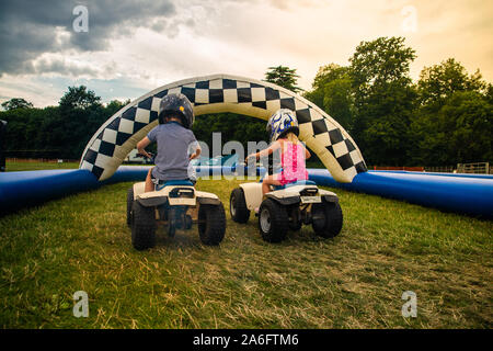 Einen kleinen Jungen mit ADHS, Autismus, Asperger-syndrom reitet ein Quad mit seiner Schwester auf ein Abenteuer Sport Tag für Kinder Stockfoto