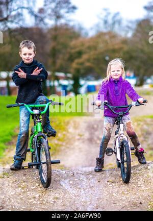 Einen kleinen Jungen mit ADHS, Autismus, Asperger-syndrom genießt einen Tag an einem BMX-Parcours reiten und Üben von Tricks mit seiner kleinen Schwester Stockfoto