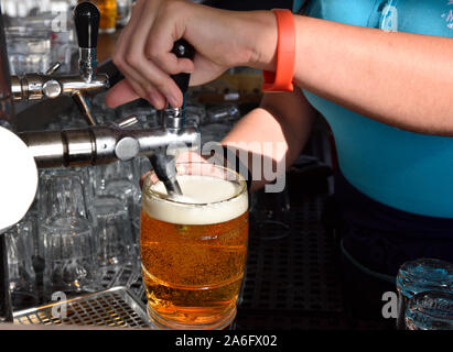 Barkeeper gießen ein frisch gezapftes Bier aus Tippen Stockfoto