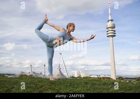 Junge Frau Yoga, Olympiapark, München, Deutschland Stockfoto