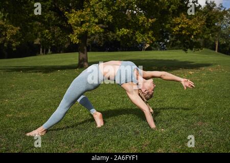 Junge Frau Yoga, Olympiapark, München, Deutschland Stockfoto