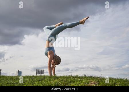 Junge Frau Yoga, Olympiapark, München, Deutschland Stockfoto