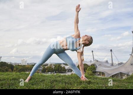 Junge Frau Yoga, Olympiapark, München, Deutschland Stockfoto