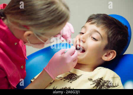 Teenager junge Patienten an den Zahnarzt. Ein Junge mit Problem Zähne in einem behandlungsstuhl Sitzen Stockfoto