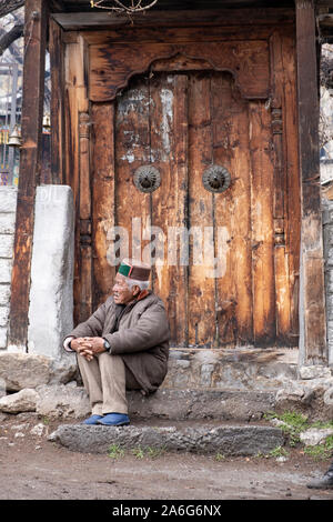 Ein alter Mann beobachtet auf einer Hochzeit Prozession vor der Haustür des alten Tempel, Chitkul, Himachal Pradesh. Stockfoto