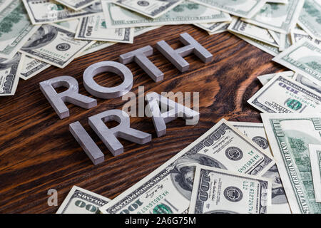 Worte ROTH IRA auf Holz- Oberfläche mit Metall Buchstaben us Papiergeld Stockfoto