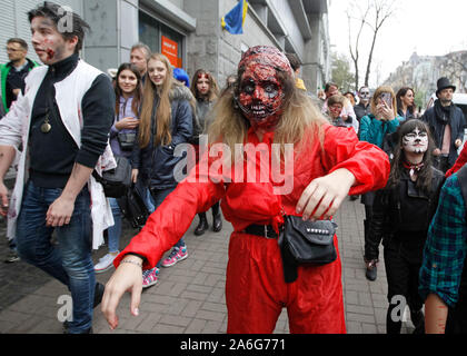 Die Teilnehmer tragen Make-up und Zombie Kostüme die Halloween Parade teilnehmen in Kiew. Hunderte von Zombies versetzt durch die Innenstadt auf der Suche nach frischem Gehirn während der Halloween Parade. Halloween ist ein Urlaub in der Welt feierte am 31. Oktober, dem Vorabend der westlichen christlichen Fest der All Hallows' Tag, in der die Teilnehmer die Halloween Kostüm Parteien teilnehmen, schnitzen Kürbisse in Jack-o'-Lanterns, Beleuchtung Lagerfeuer, Apple bobbing, Streiche spielen, erzählen Gruselgeschichten und Horror Filme. Stockfoto