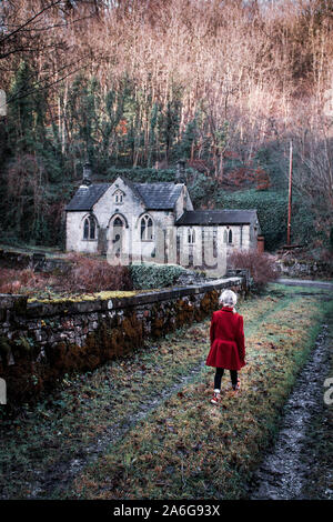 Kleines Mädchen auf dem Weg zu einem unheimlichen Haus, Landschaft, Haunted, Wald, gruselige, unheimlich, beängstigend, Haus, Buchcover, Gebäude, Kind im Land Großbritannien, verlassen Stockfoto