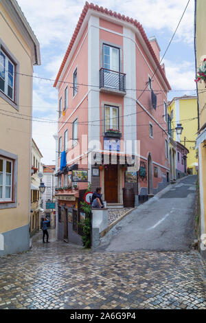 Zwei Menschen und engen gepflasterten Gassen und bunten Gebäude an der idyllischen Altstadt von Sintra in Portugal in den Morgen. Stockfoto