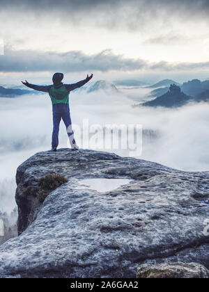 Mann auf erfolgreiche Wanderung, Silhouette in niedrigen Berge der Sächsischen Schweiz. Wanderer auf dem Berg am wunderschönen nebligen Landschaft suchen Stockfoto