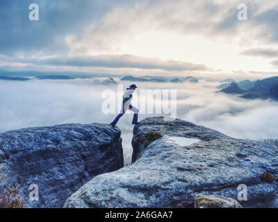 Mann auf erfolgreiche Wanderung, Silhouette in niedrigen Berge der Sächsischen Schweiz. Wanderer auf dem Berg am wunderschönen nebligen Landschaft suchen Stockfoto