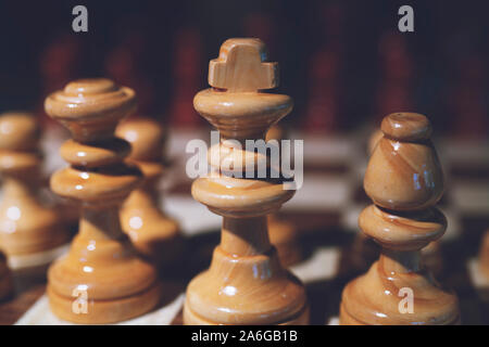 Noch immer leben Hautnah Detailansicht einer König Schach Holz- stück auf einem Schachbrett, während ein strategisches Spiel gespielt wird. Professionelle Spiel spielen. Stockfoto