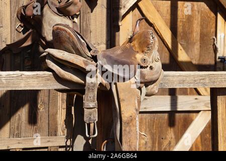 Alte, geschlagen bis Sattel ruht auf Holz- Schiene Stockfoto