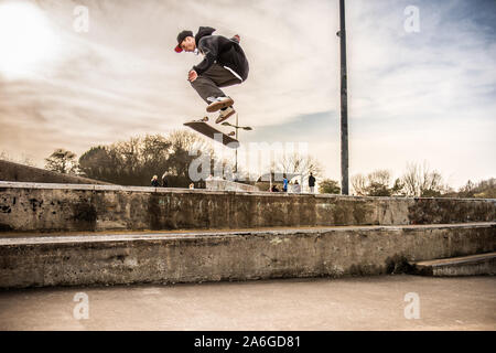 Ein Skateboarder Ollie's eine sehr hohe Double Step an der Skate Park, einige schwere Luft Stockfoto