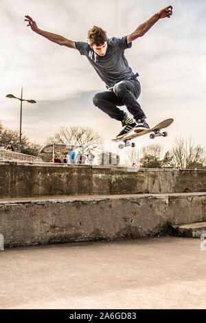 Ein Skateboarder Ollie's eine sehr hohe Double Step an der Skate Park, einige schwere Luft Stockfoto