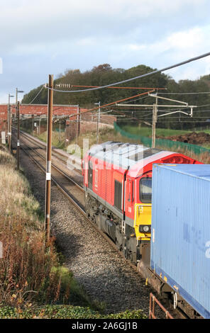 DB Cargo UK Class 66 diesel-elektrischen Lokomotive 66104 in DB Cargo livery Schleppen container Zug auf der West Coast Main Line am 26. Oktober 2019. Stockfoto