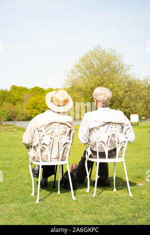 Ein älteres Ehepaar von Männern sitzen auf Stühlen Sonnenbaden in Walton auf der Naze, Essex Stockfoto