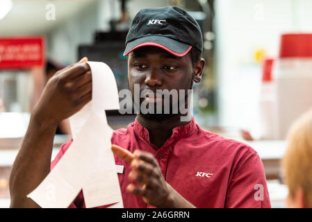 Eine schwarze KFC Arbeitnehmer Stefan an der lokalen Kentucky Fried Chicken, KFC weg Steckdose an. Stockfoto