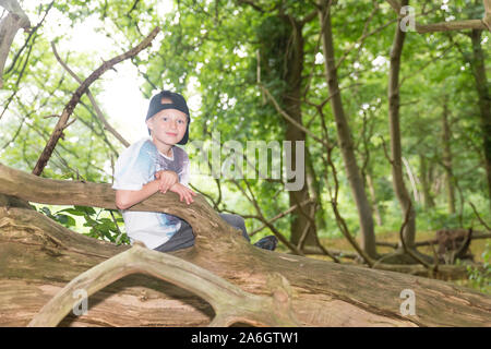 Ein kleiner Junge sitzt in einem Maisfeld tragen eine Baseballmütze, beim Spielen mit Freunden Stockfoto