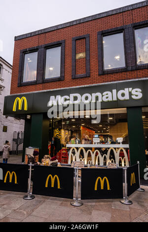 Die Menschen genießen einen schönen warmen McDonalds Essen außerhalb nach dem Shopping in der Januar- und Weihnachtsgeschäft an einem kalten Januar Tag Stockfoto